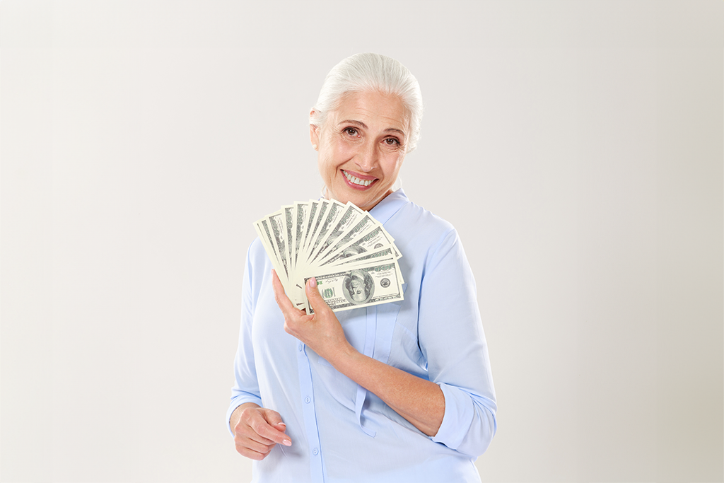 Mujer sonriente sosteniendo billetes de dólar
